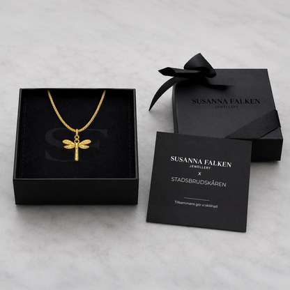 Svart presentask från Susanna Falken Jewellery med Vingkraft Halsband i guld, svart sidenband och tillhörande kort om smyckets betydelse.