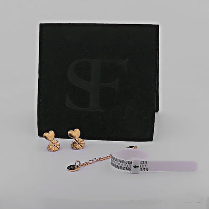 Svart smyckespåse från Susanna Falken Jewellery fylld med måttband för fingrar, förlängningskedja och Stadig Snurrebuss i valbar färg – silver eller guld – på vit bakgrund.